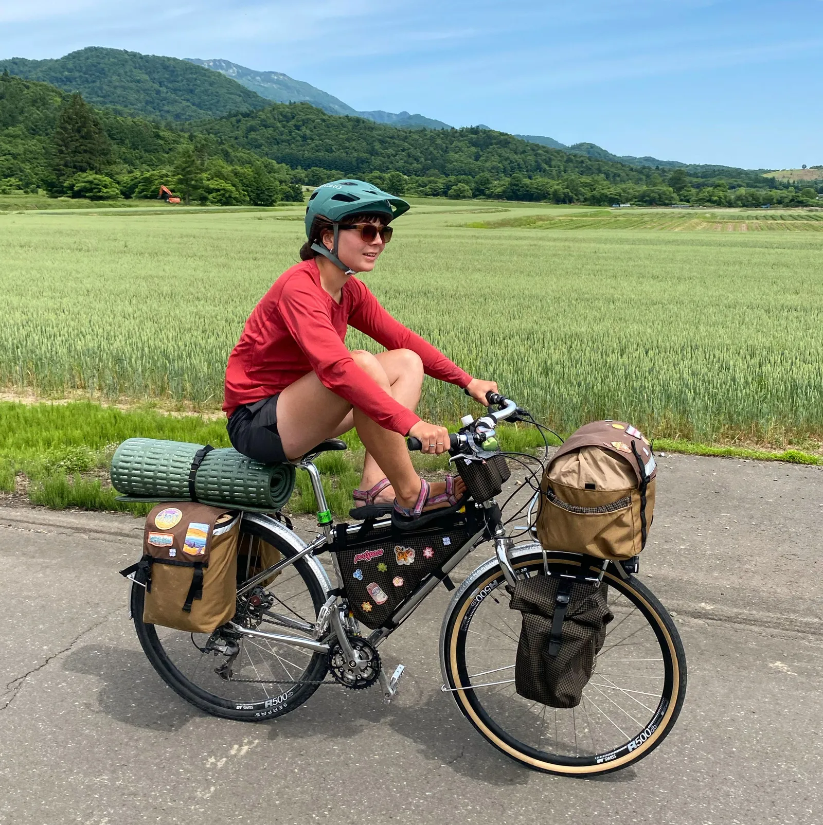 Taylor with her legs up on her bike frame and a loaded bike