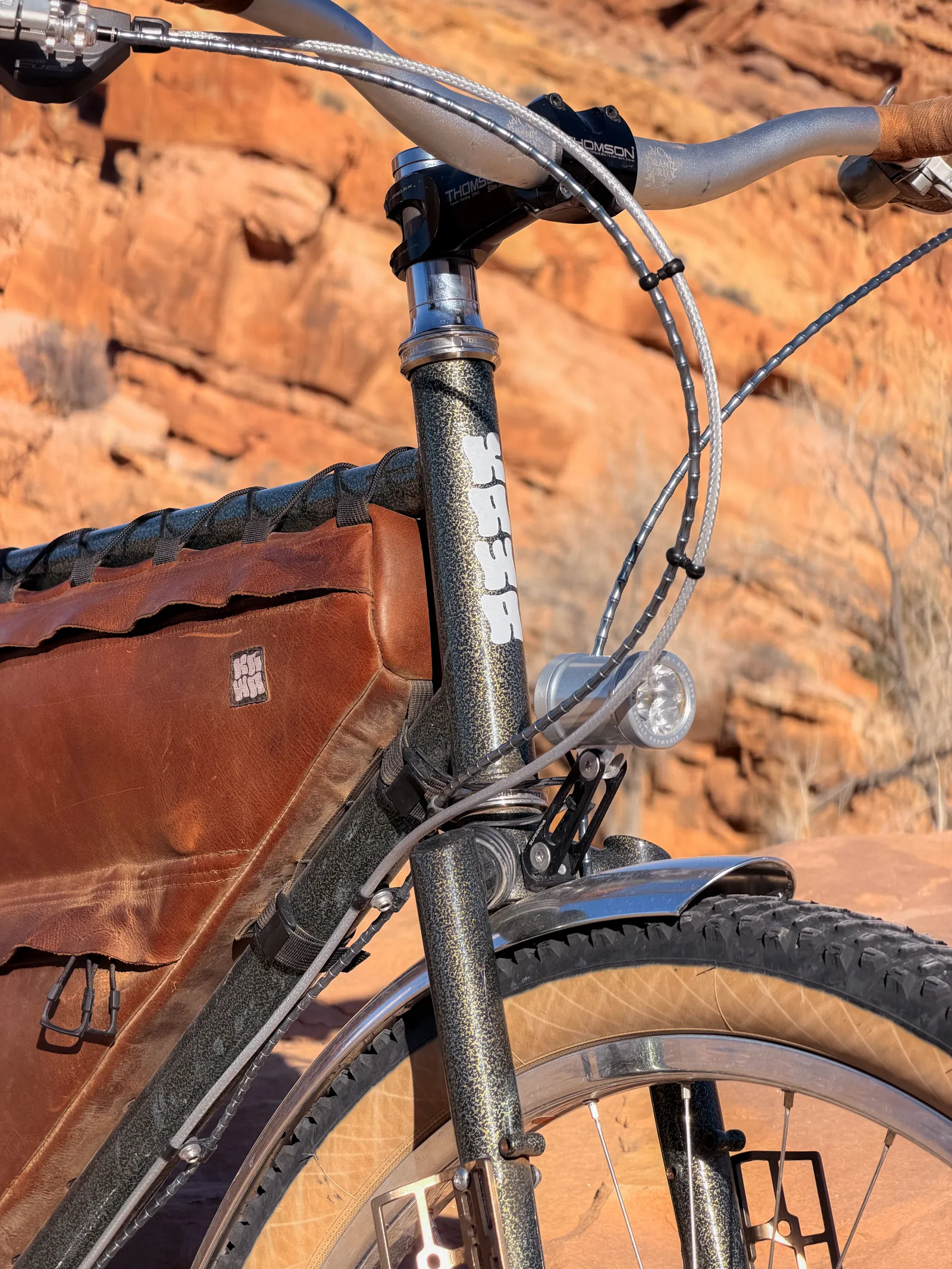 Close-up of the fork and headtube showing the pebble paint texture and Sinewave dynamo light