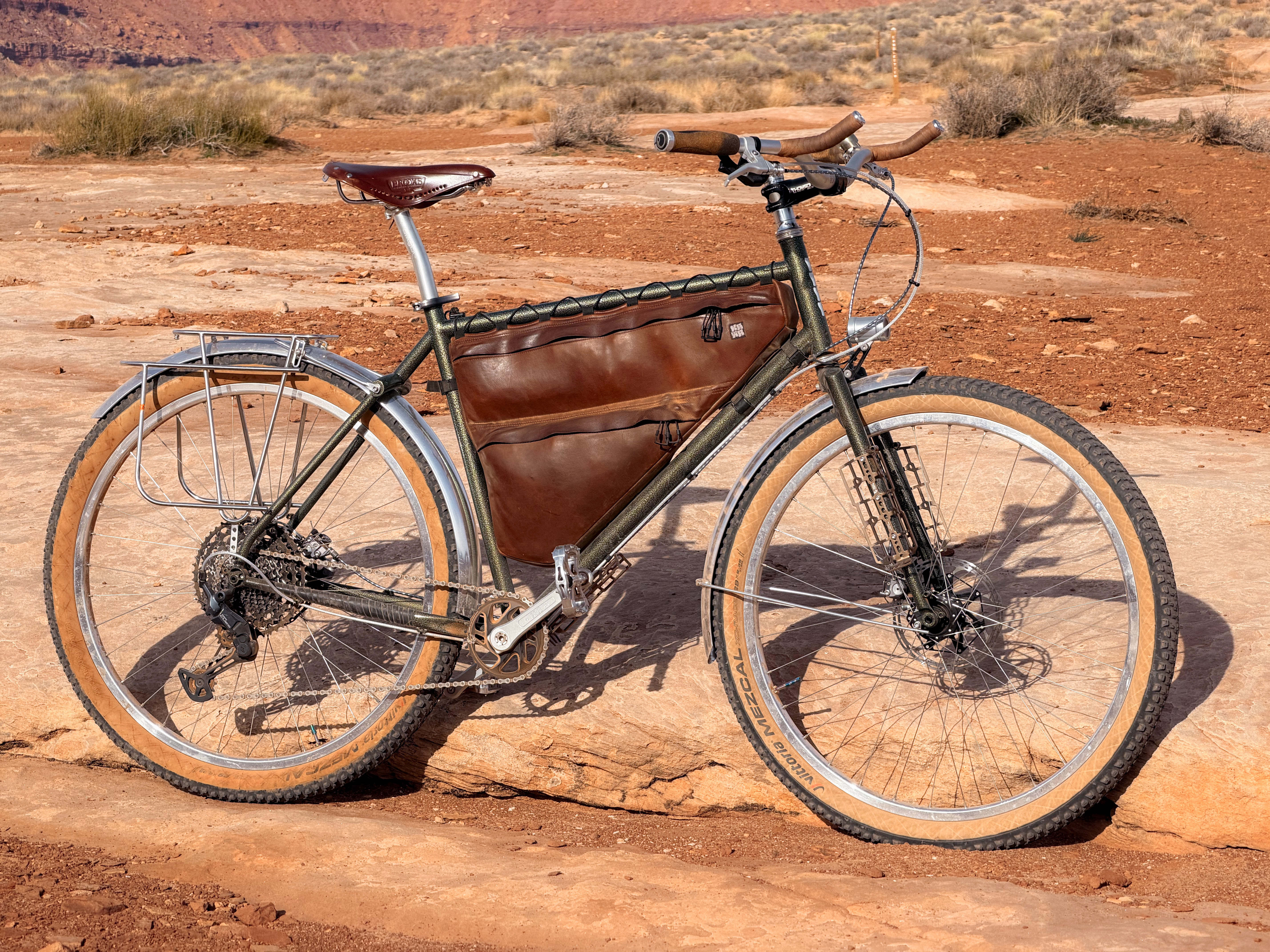 Full bike shot showing the custom muted green paint against red desert terrain